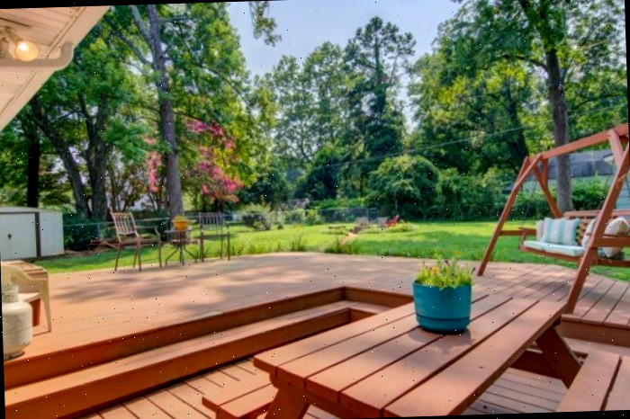Deck traseiro em dois níveis com balanço manchado e mesa de piquenique