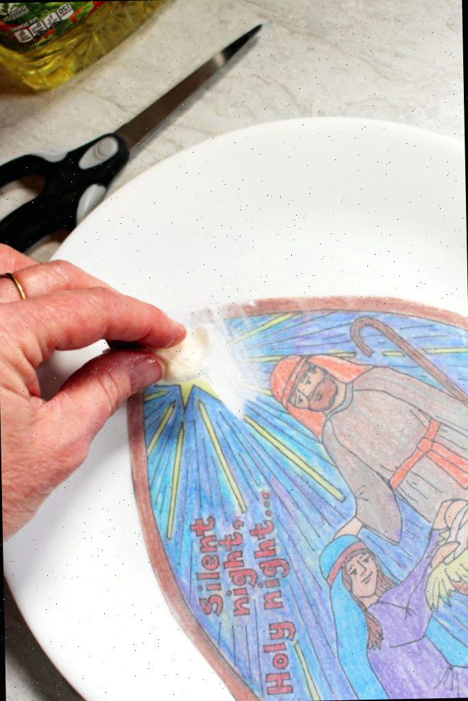 Limpando o óleo na parte de trás da página para colorir para um efeito de vitral.