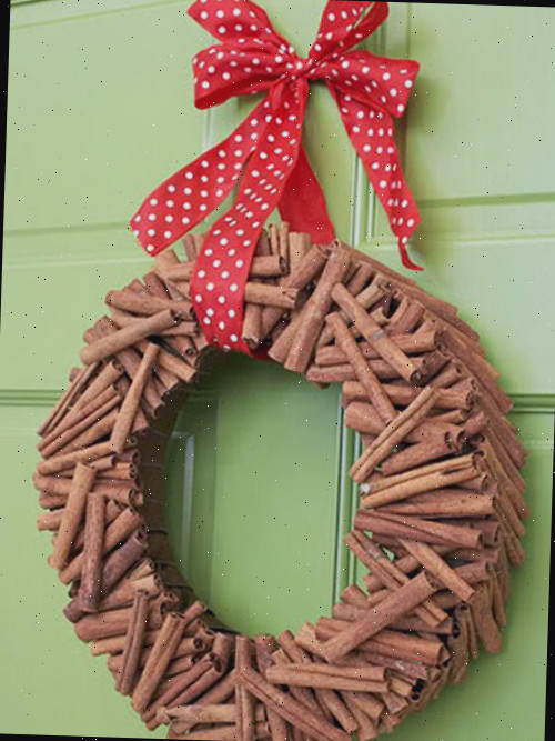 Guirlanda de Palitos de Canela do bhg.com em uma porta verde com um laço vermelho e branco.