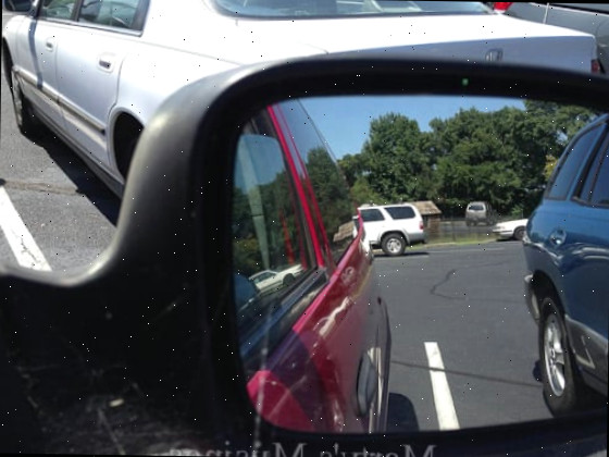 Um carro estacionado em frente a um espelho posando para a câmera