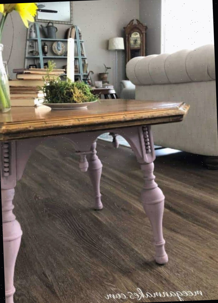 Uma sala de estar cheia de móveis e um vaso de flores sobre uma mesa