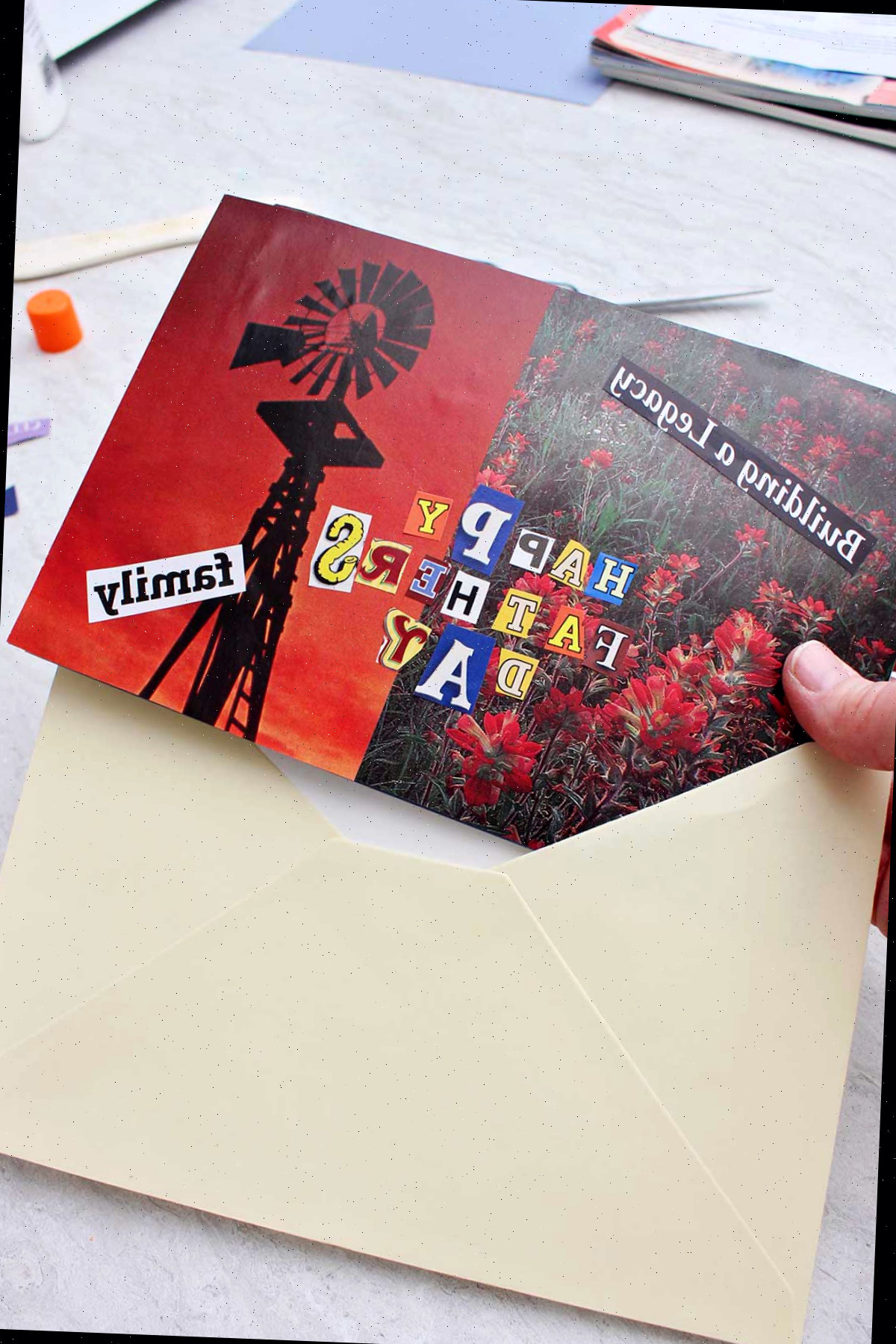 Indivíduo colocando o cartão do Dia dos Pais completo em um envelope off-white.