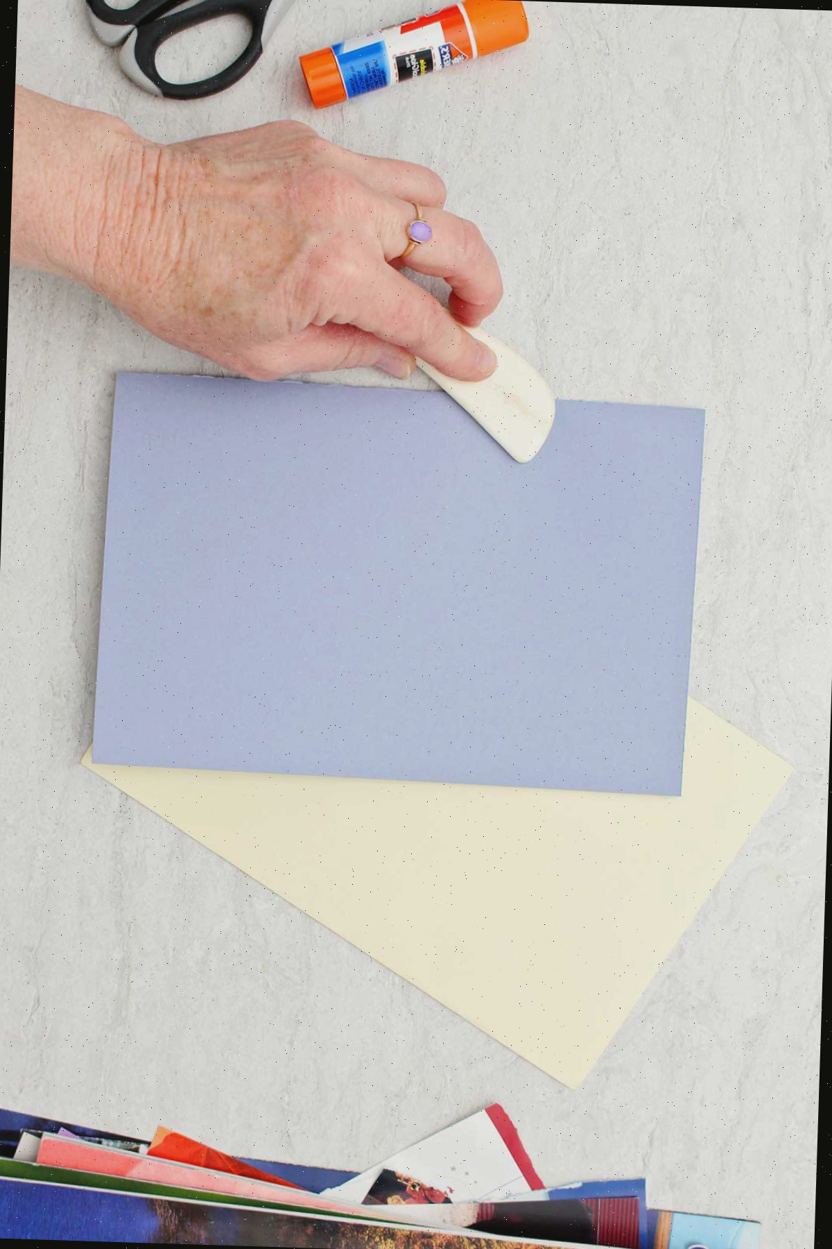 Pessoa usando um marcador para dobrar um pedaço de papel roxo para o cartão do Dia dos Pais.