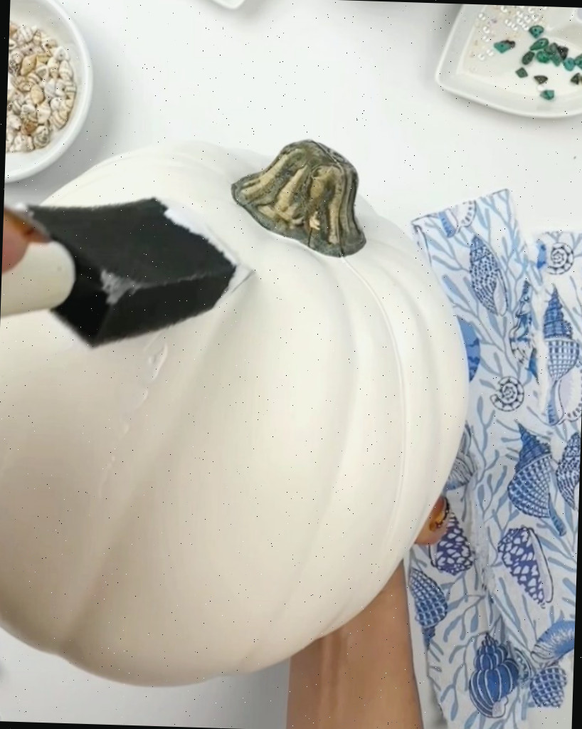 adicionando mod podge à abóbora antes da decoupage