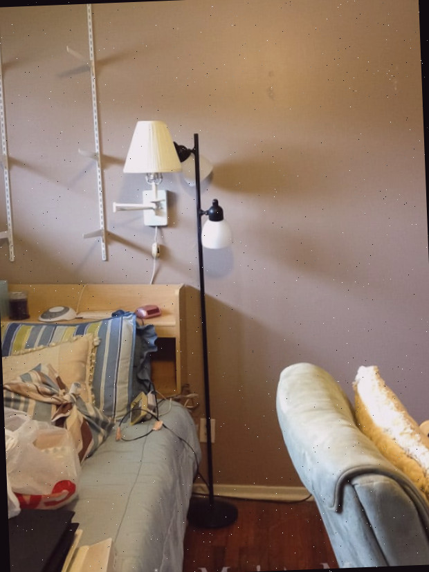 Um quarto com uma cama e uma mesa em um cômodo