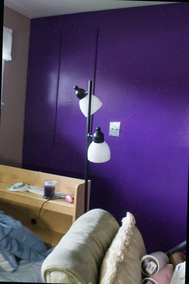 Um quarto com uma cama e uma mesa em um cômodo