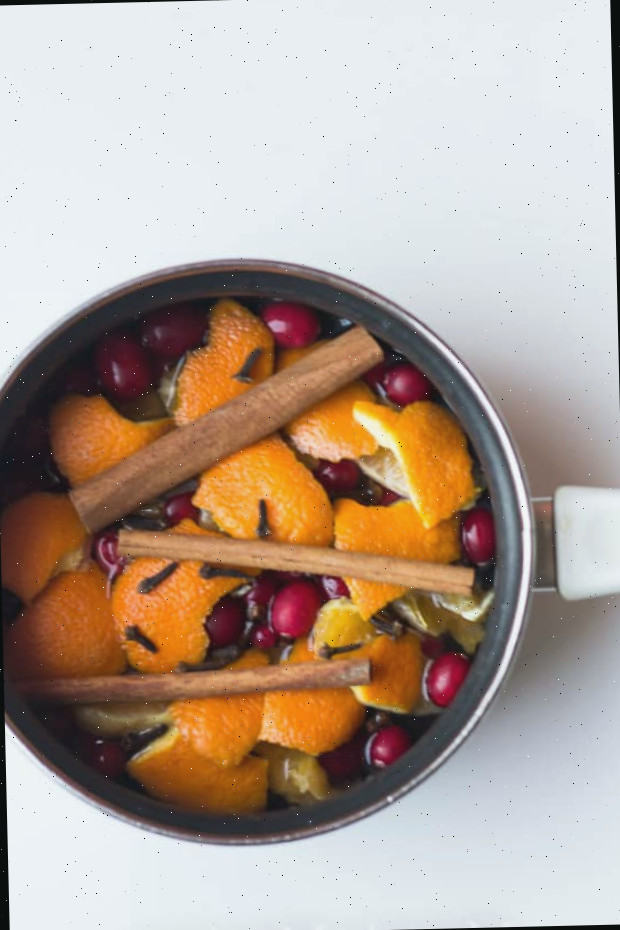 Pot-pourri artesanal em uma panela com laranjas, paus de canela e cranberries
