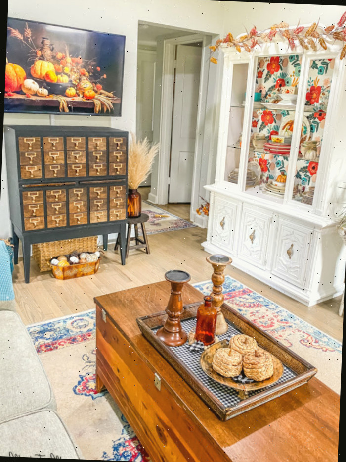 Sala de estar diminuta com aparador branco e coleções de cartões vintage decorados para o outono