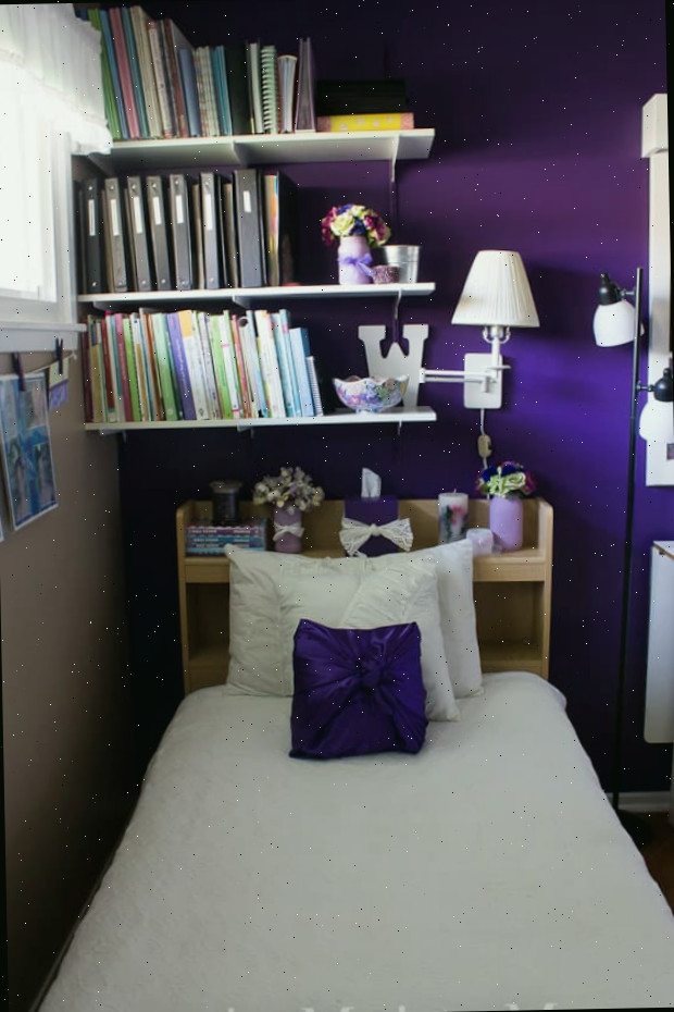 Um quarto com uma cama e uma mesa em um pequeno espaço