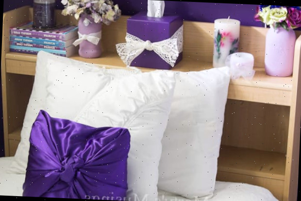 Uma cama de casal com uma flor roxa