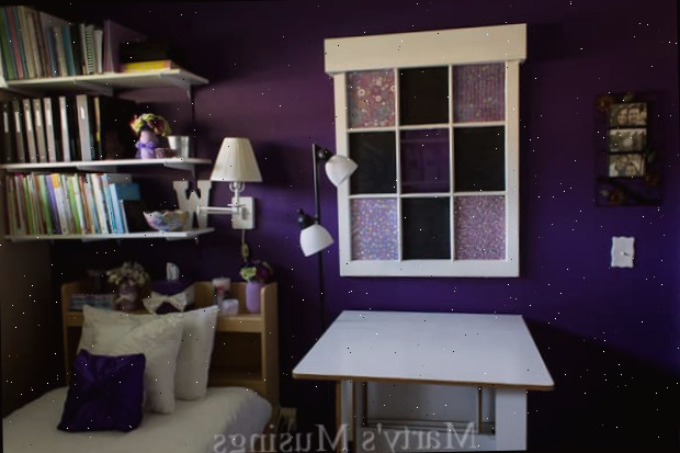 Um quarto com uma cama e uma mesa em um pequeno espaço