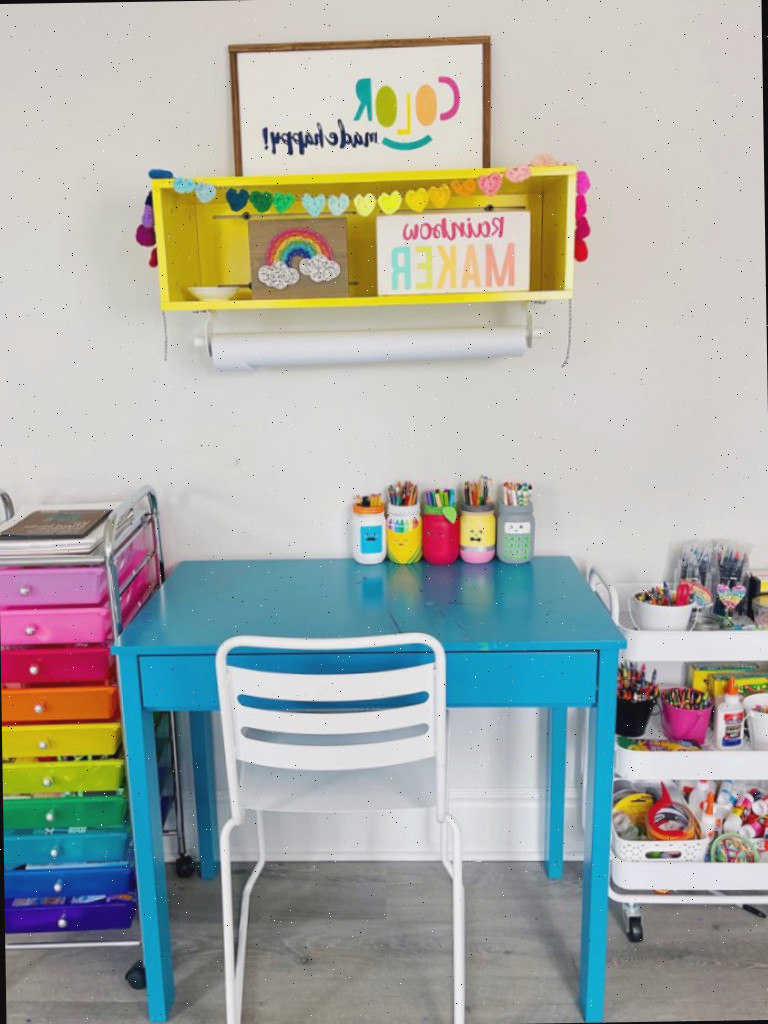 Carrinhos de armazenamento com rodas ao lado de uma mesa pequena para criar um espaço de artesanato organizado