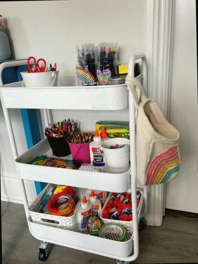 Carrinho de organização branco para quarto de artesanato repleto de suprimentos