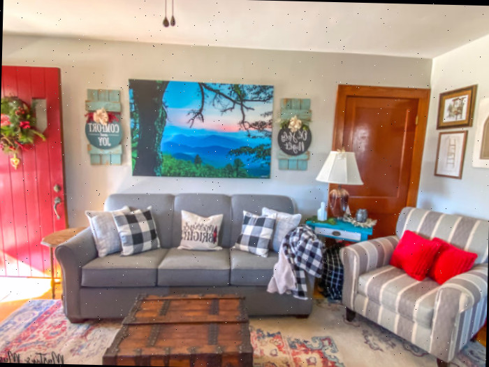 Sala de estar de casa em estilo craftsman adornada para o Natal com xadrez buffalo preto e branco e detalhes em vermelho