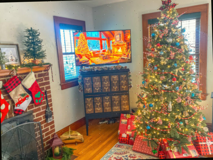 Árvore de Natal com ornamentos vermelhos e azuis na sala de estar