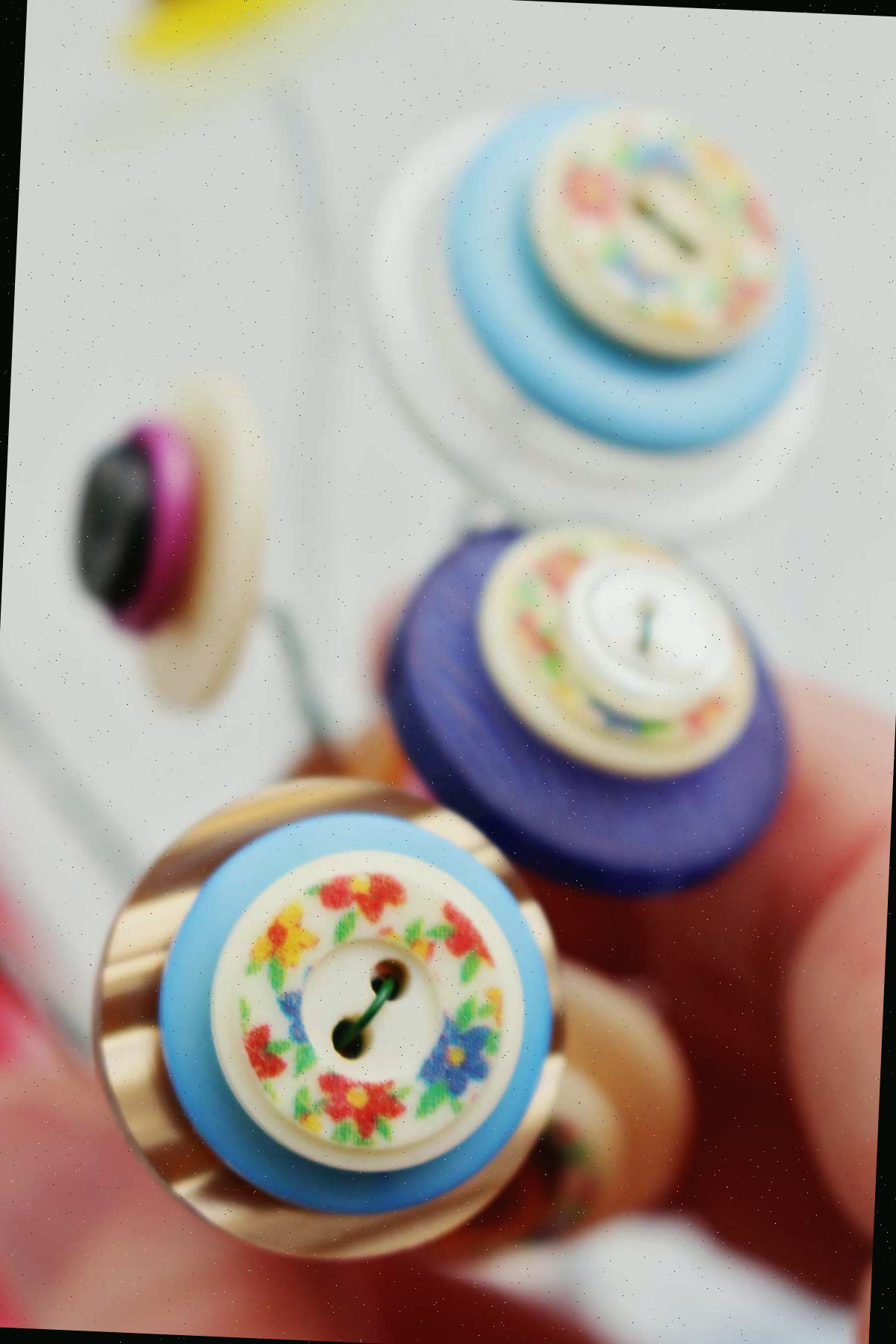 Close up de botões coloridos em camadas fixados com fio floral.