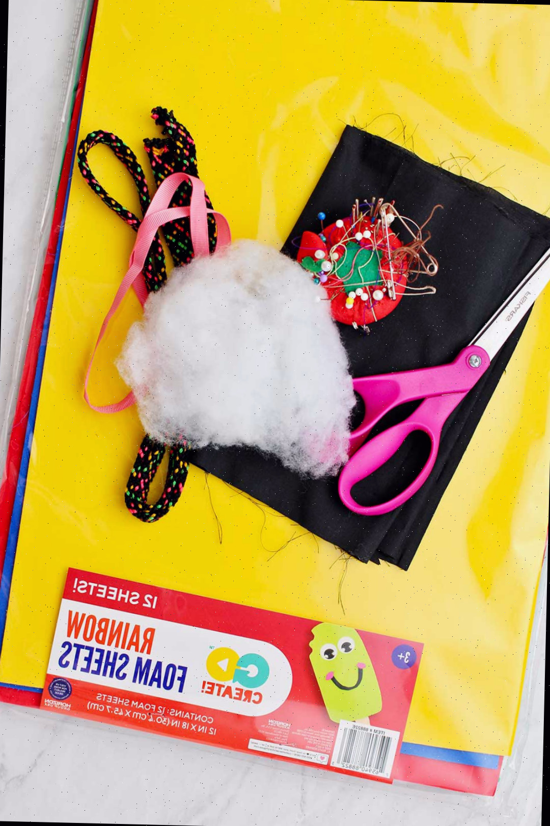 Um conjunto de folhas de espuma coloridas e vários materiais para criar a fantasia de gato preto para o Halloween.