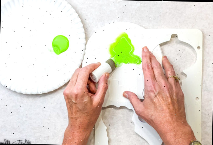 Aplicando carimbo com tinta verde e estêncil branco