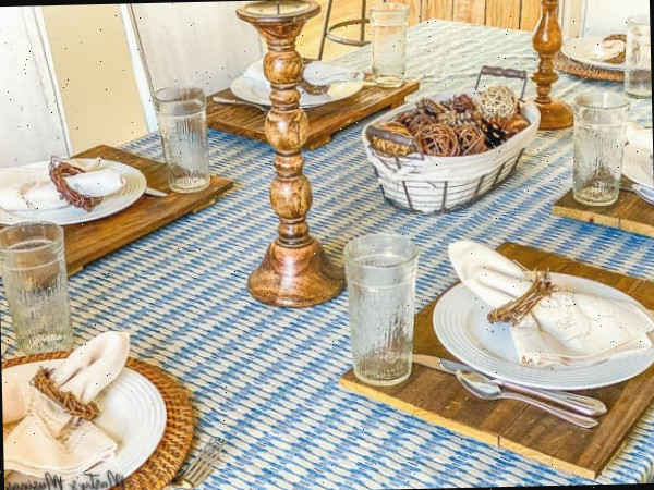 toalha azul usada como caminho de mesa com detalhes em madeira e louça branca
