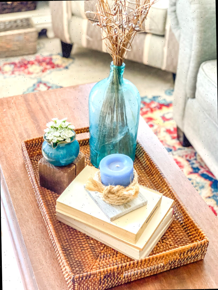 pequena composição com bandeja de vime, livros e acessórios em azul