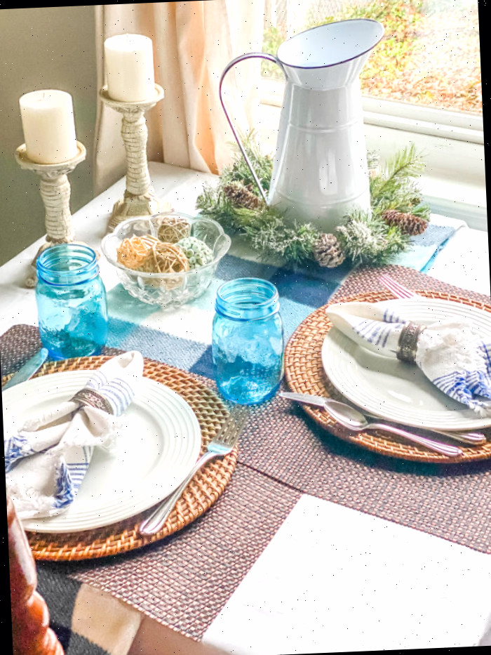 manta azul usada com detalhes azuis e louça branca sobre mesa de cozinha pequena