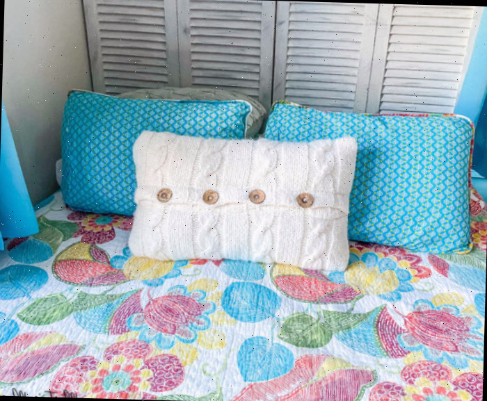 cabeceira elaborada com porta de armário e colcha estampada em azul-turquesa