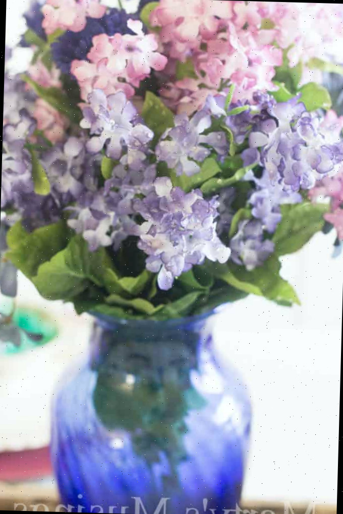Um close de um vaso com uma flor roxa
