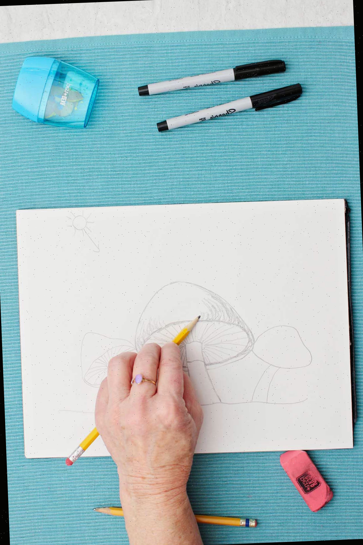 Um desenho a lápis de um cogumelo, o artista adicionando a sombra