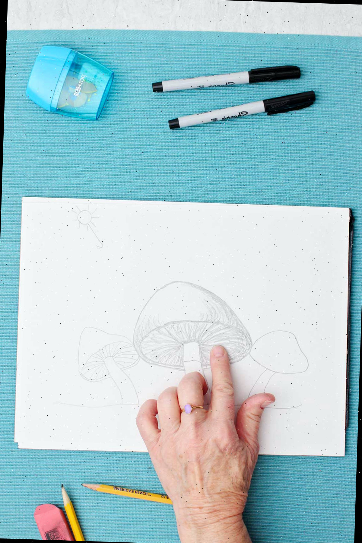 Um esboço a lápis de um cogumelo, o artista aplicando a sombra