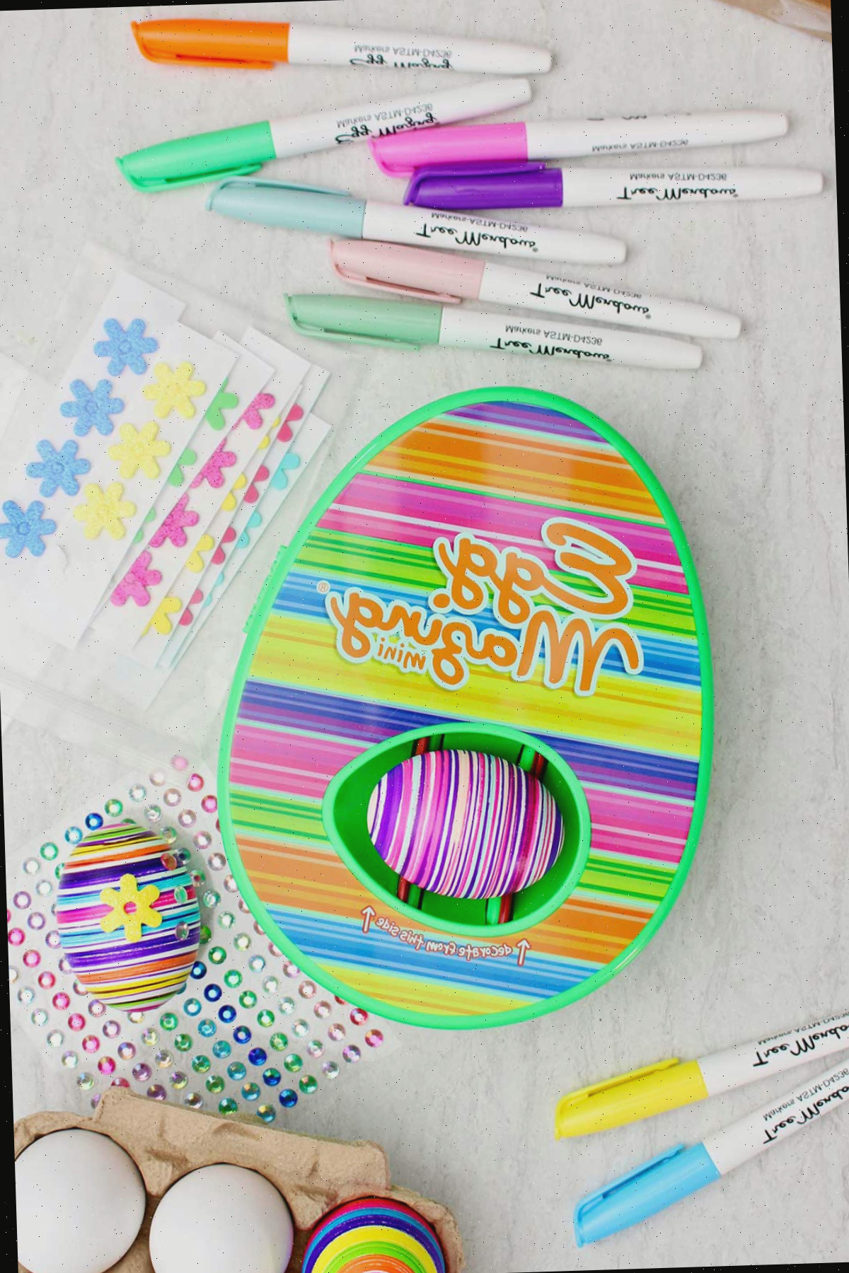 Kit de design listrado EggMazing com ovo colorido listrado dentro e outros materiais ao redor.