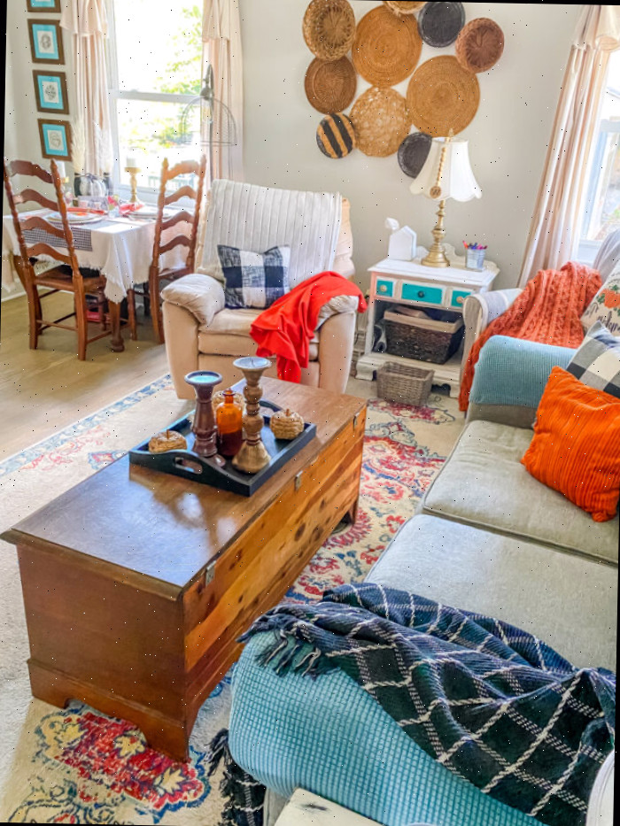 Sala de estar decorada para o outono com detalhes xadrez em laranja e preto