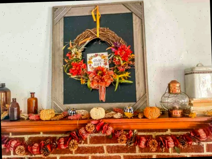 Manto de outono com quadro-negro preto e guirlanda pendurada no topo. Bandeirolas e acessórios vintage