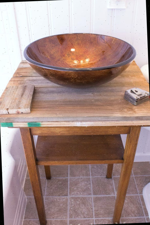 Uma tigela marrom em cima de uma mesa de madeira, com Banheiro e Cerca