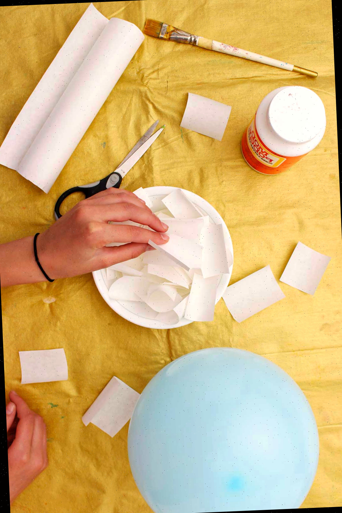 Indivíduo pegando um pedaço de papel machê.