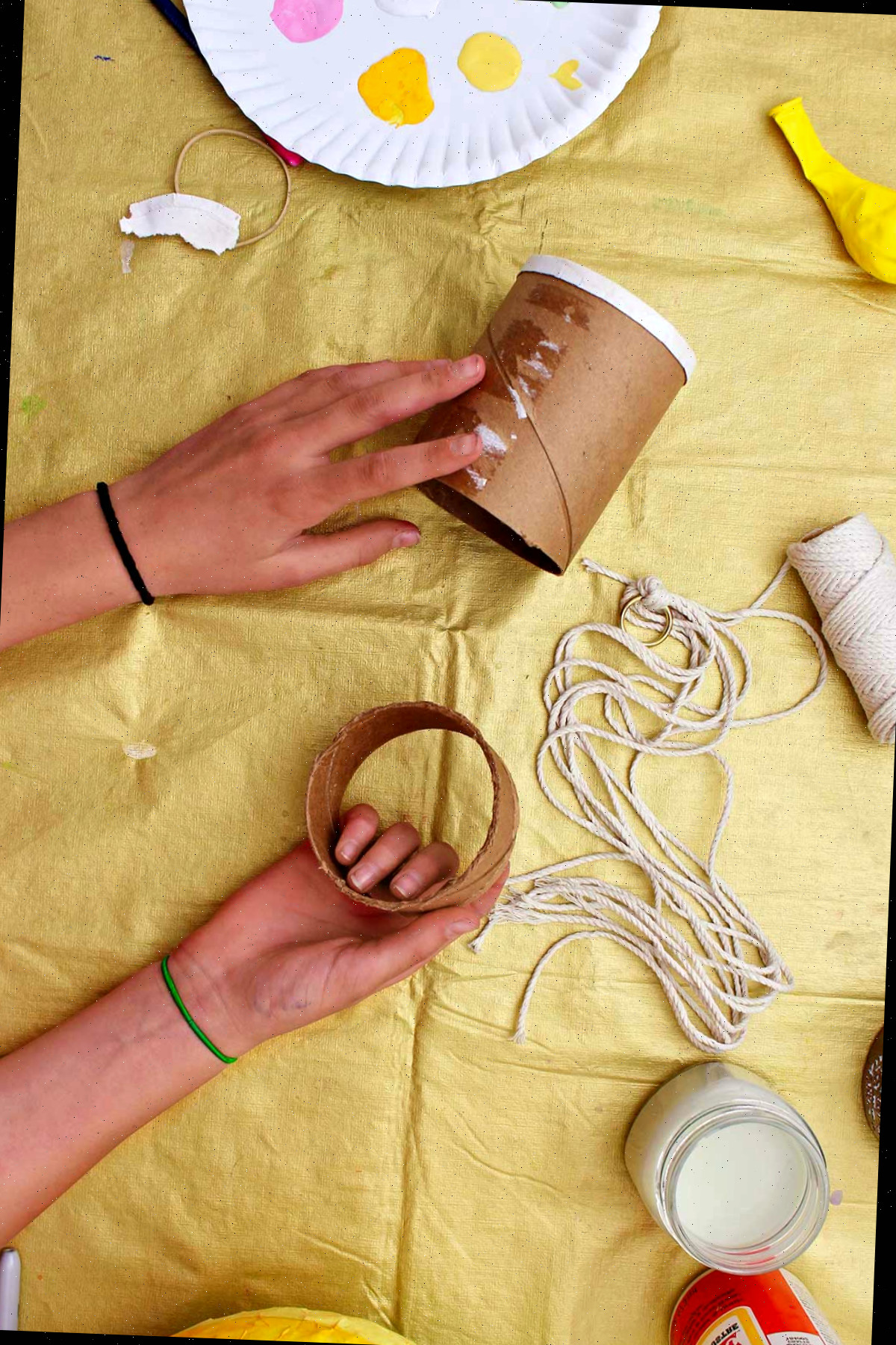 Indivíduo cortando a parte inferior de um tubo de papelão para usar como base para seu artesanato de balão de ar quente.