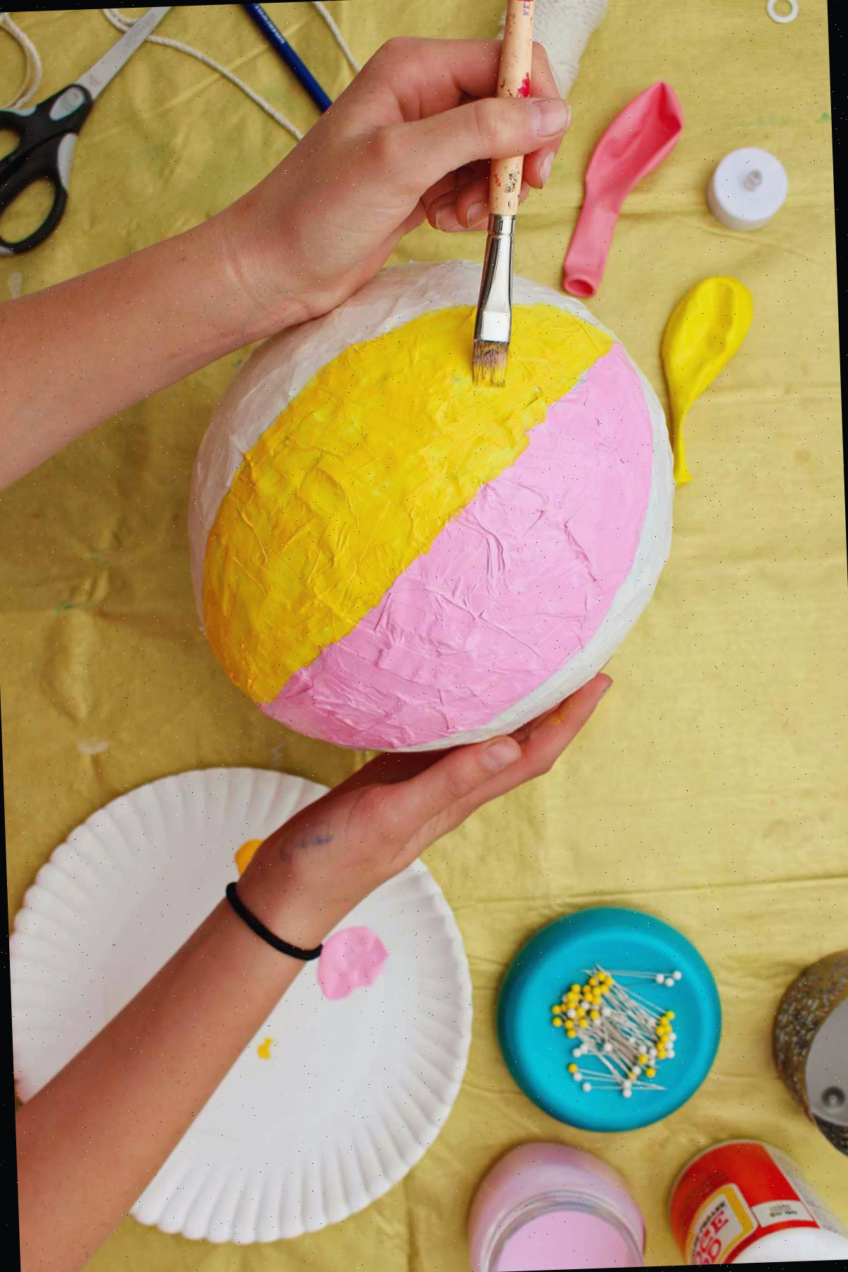 Indivíduo pintando uma faixa amarela em seu balão de ar quente.