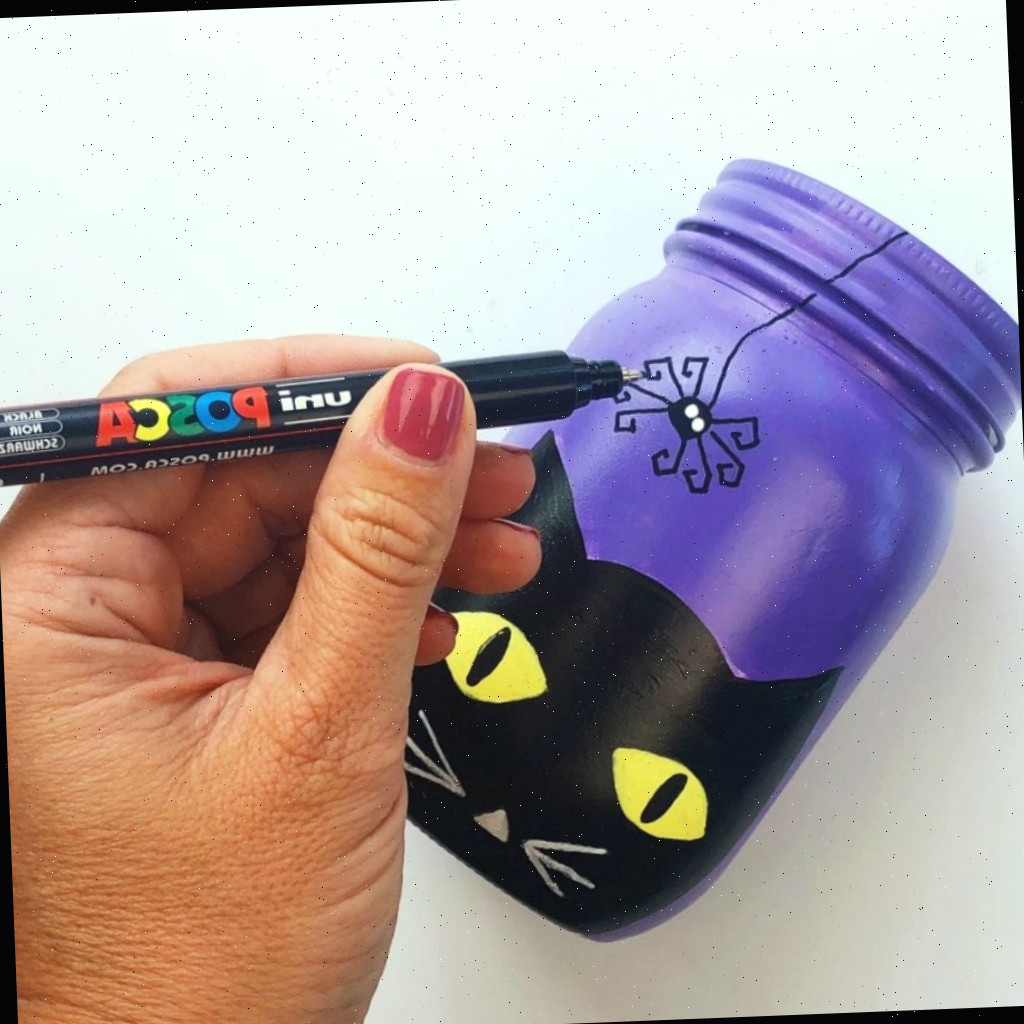 Desenhando uma aranha no frasco de conserva com uma caneta de tinta fina