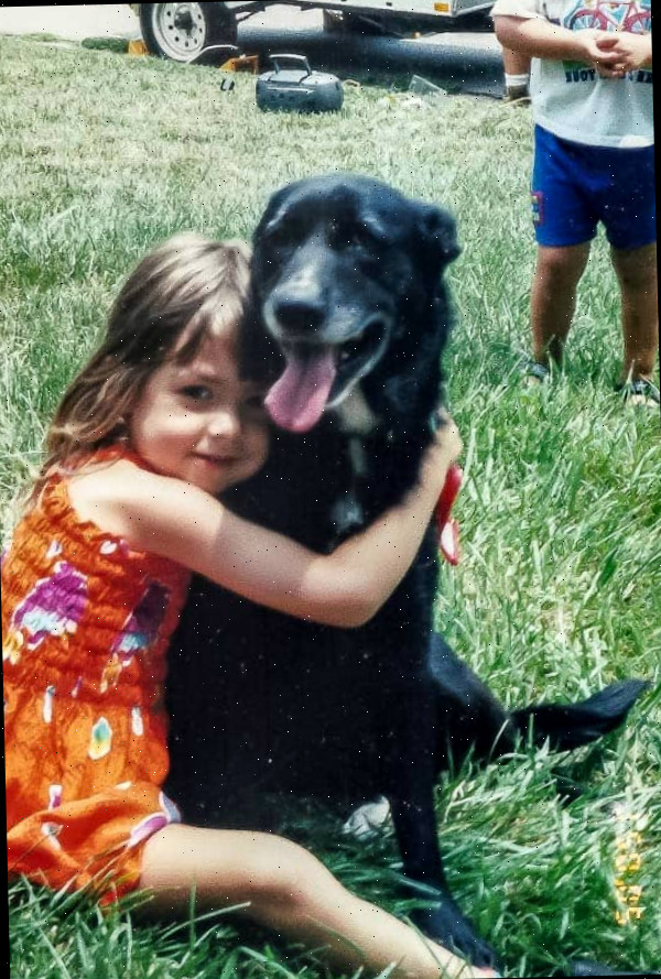 Uma menina pequena segurando um cachorro