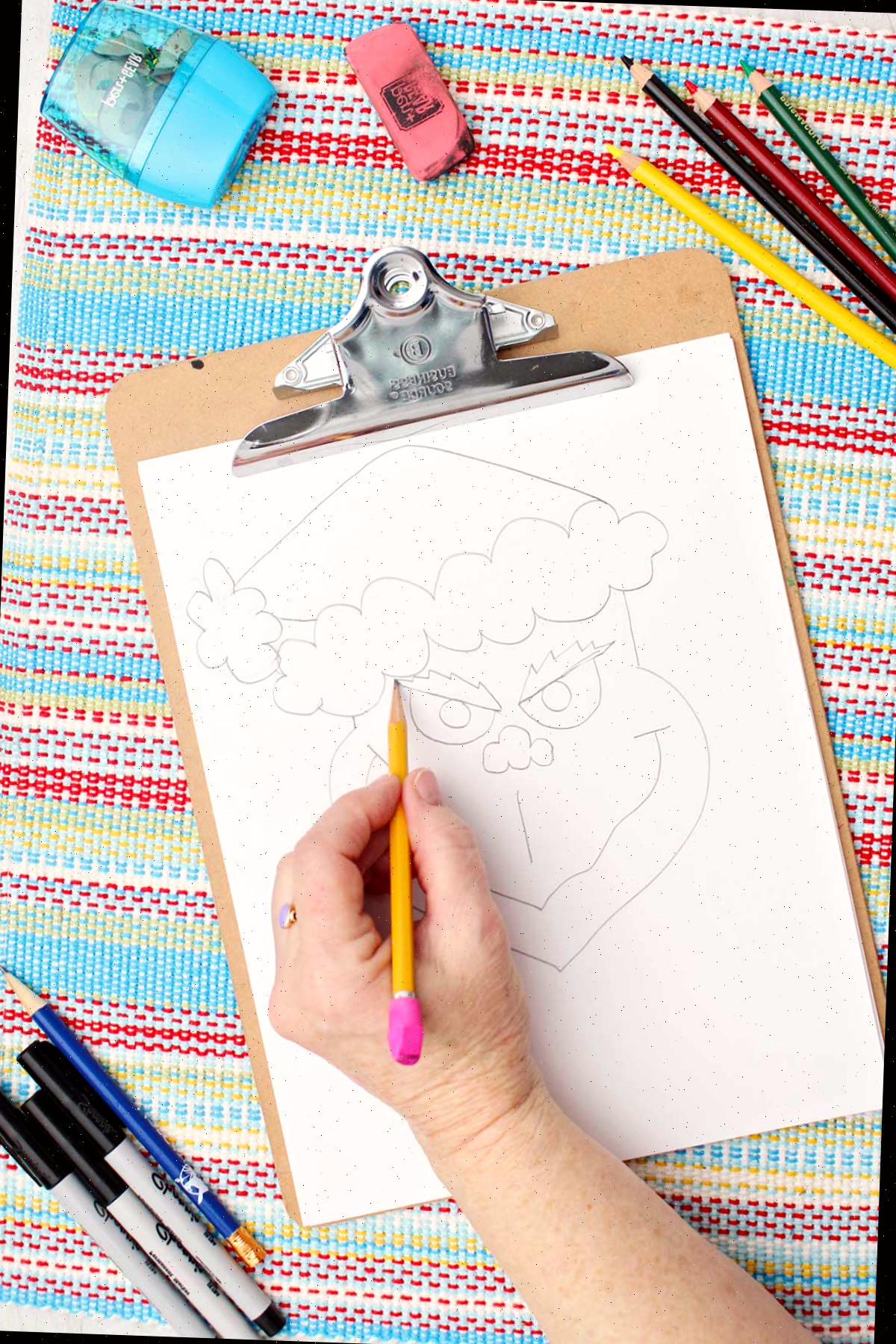 Indivíduo desenhando sobrancelhas no rascunho do Grinch.