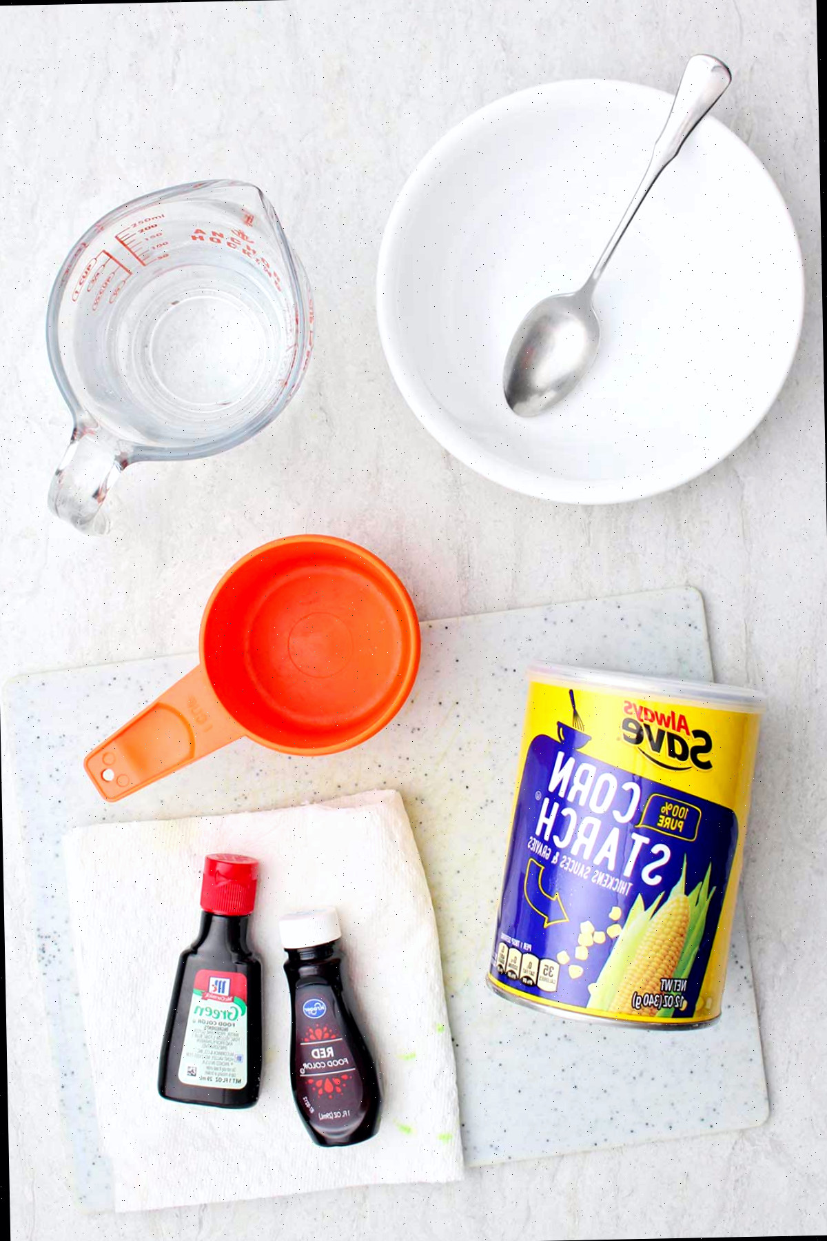 Ingredientes para oobleck. Amido de milho, água e corante alimentar com outros utensílios de cozinha para criar oobleck.