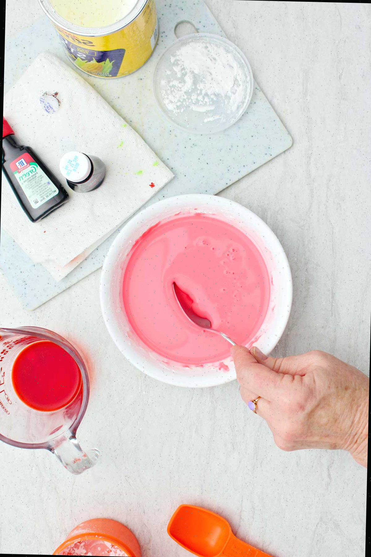 Uma pessoa misturando uma tigela de ingredientes para oobleck rosa.