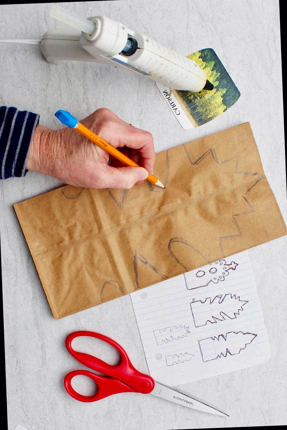 Desenho manual em estêncil em sacos de papel marrons.