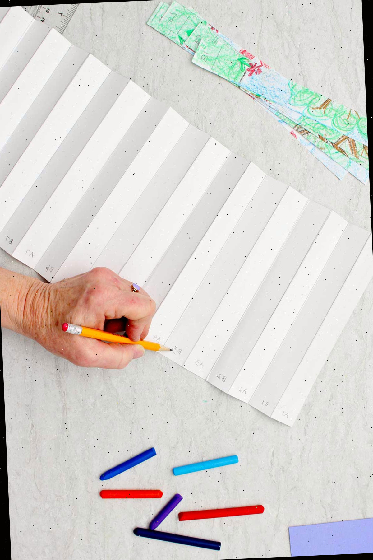 Indivíduo numerando onde cada tiras do desenho deve ser colocado, alternando entre o desenho A e o desenho B.