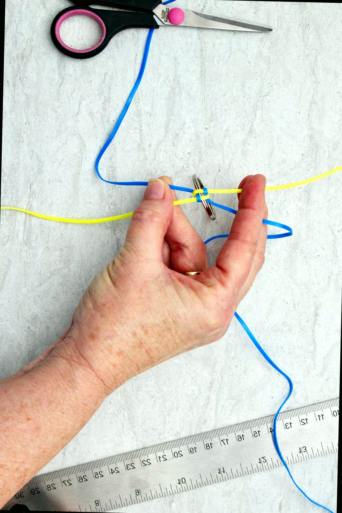 Entrelaçando um chaveiro boondoggle amarelo e azul.