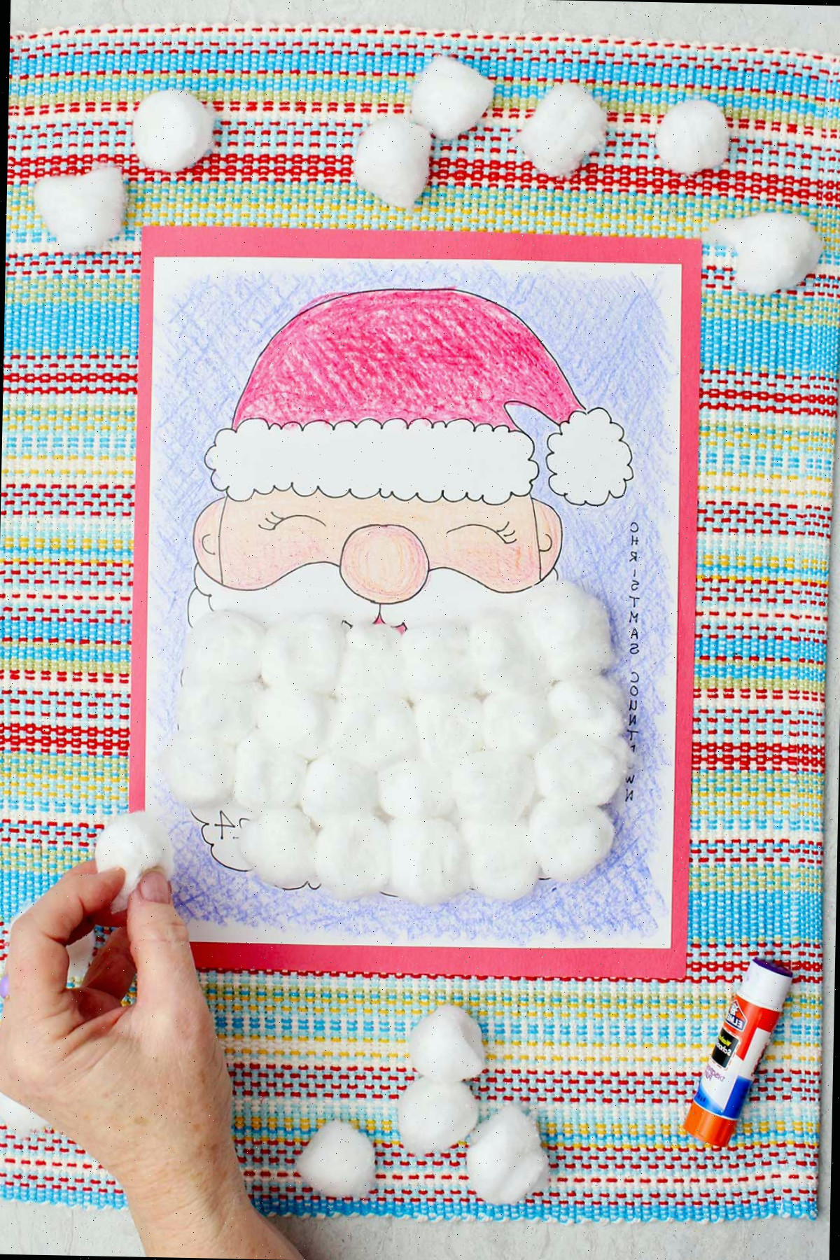 Uma pessoa adicionando uma bolinha de algodão em um dia na barba do Papai Noel no calendário de contagem regressiva.