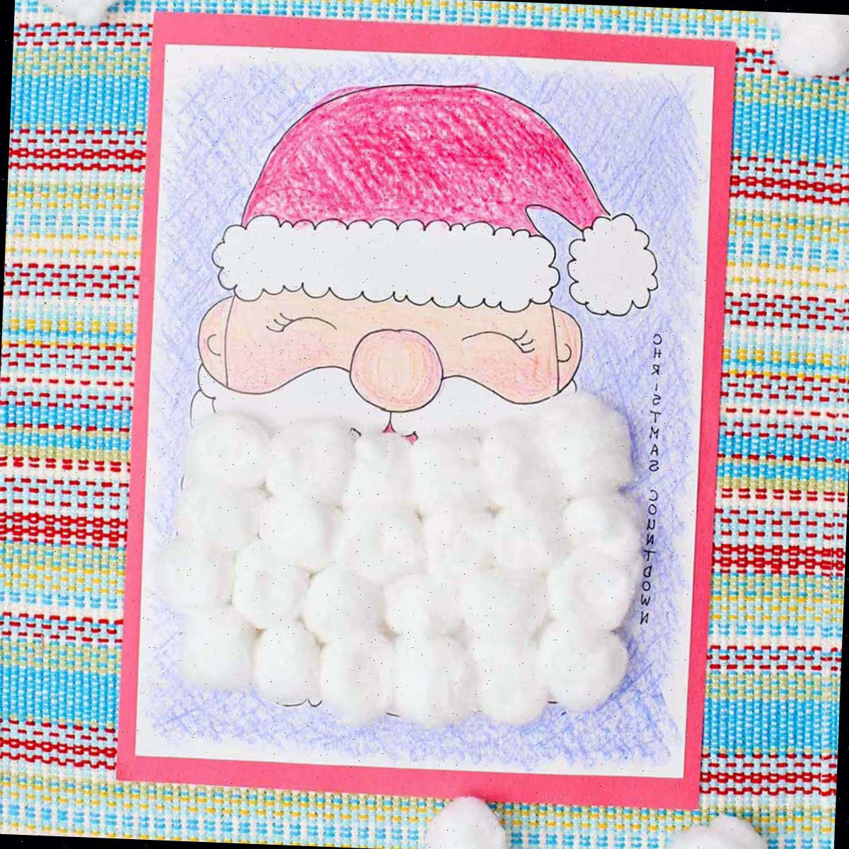 Um calendário de contagem regressiva de Natal completo, colorido com giz de cera e a barba do Papai Noel coberta com bolas de algodão.