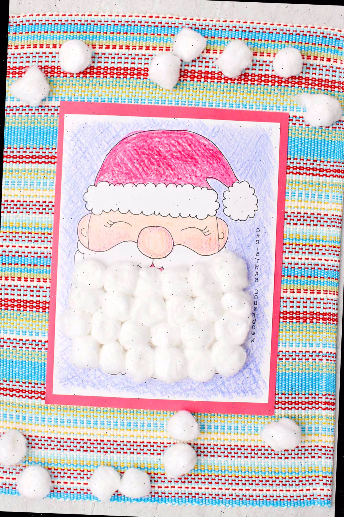 Um calendário de contagem regressiva de Natal completo, colorido com giz de cera e a barba do Papai Noel coberta com bolinhas de algodão.