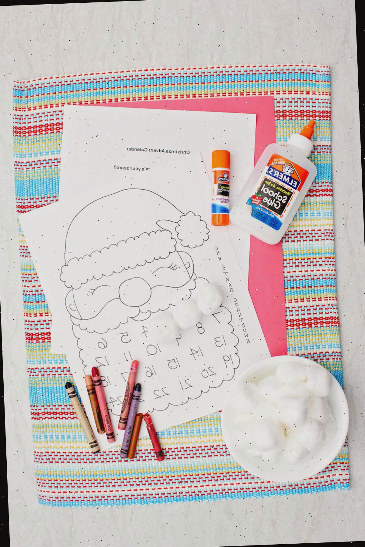 Materiais necessários para um calendário de contagem regressiva do Papai Noel. Um imprimível do Papai Noel, bolinhas de algodão, cola e lápis de cor.