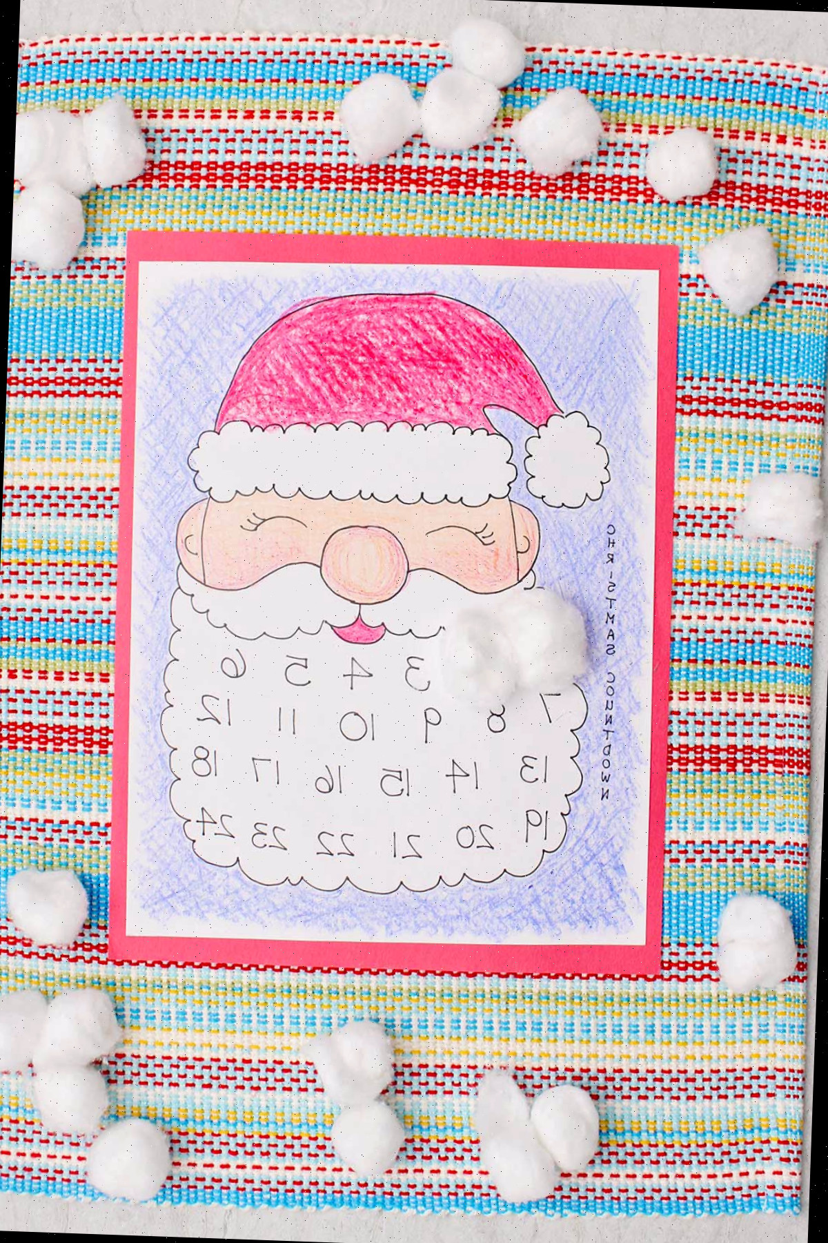 Um calendário do Papai Noel colorido impresso com os dias um e dois cobertos por uma bolinha de algodão na barba do Papai Noel.