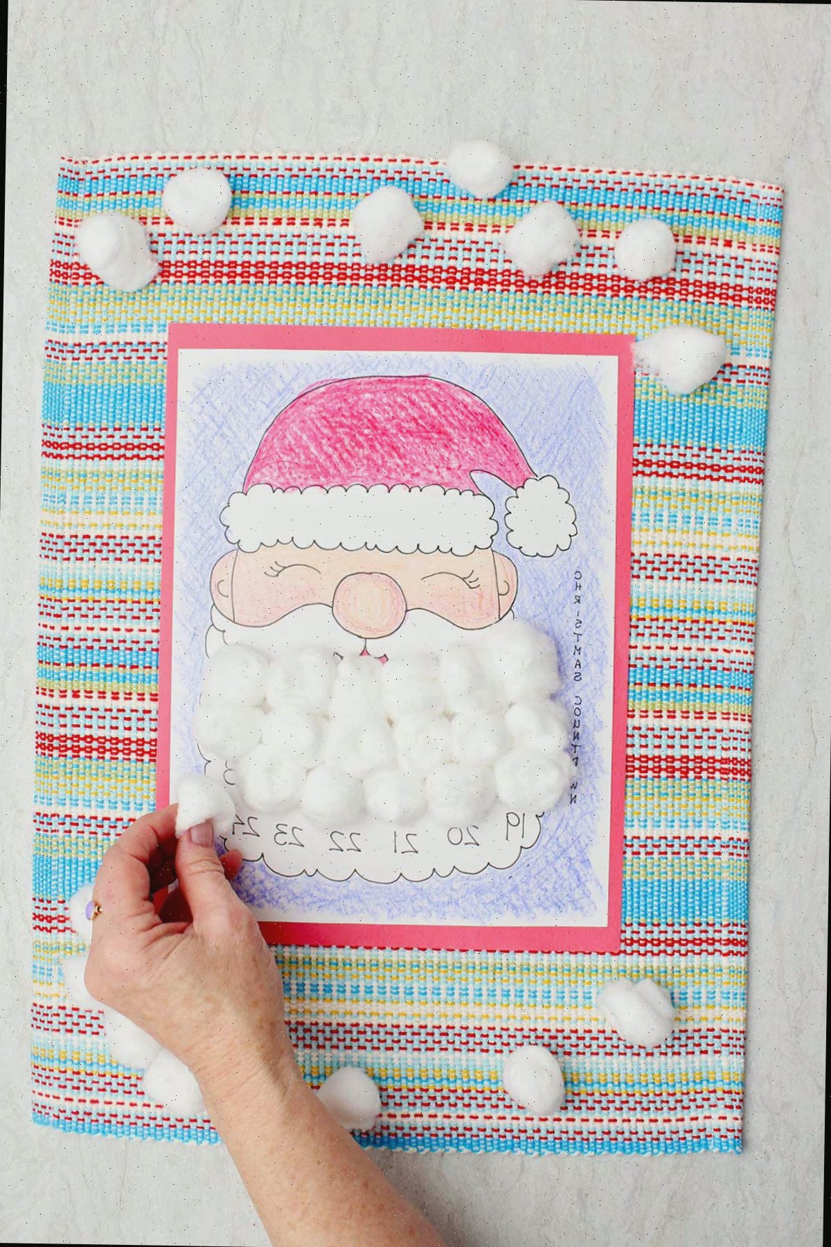 Uma pessoa colocando uma bolinha de algodão em um dia da barba do Papai Noel no calendário de contagem regressiva.